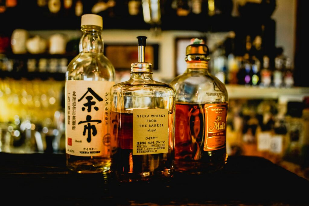 Selection of Japanese whisky bottles displayed in a dimly lit bar setting.